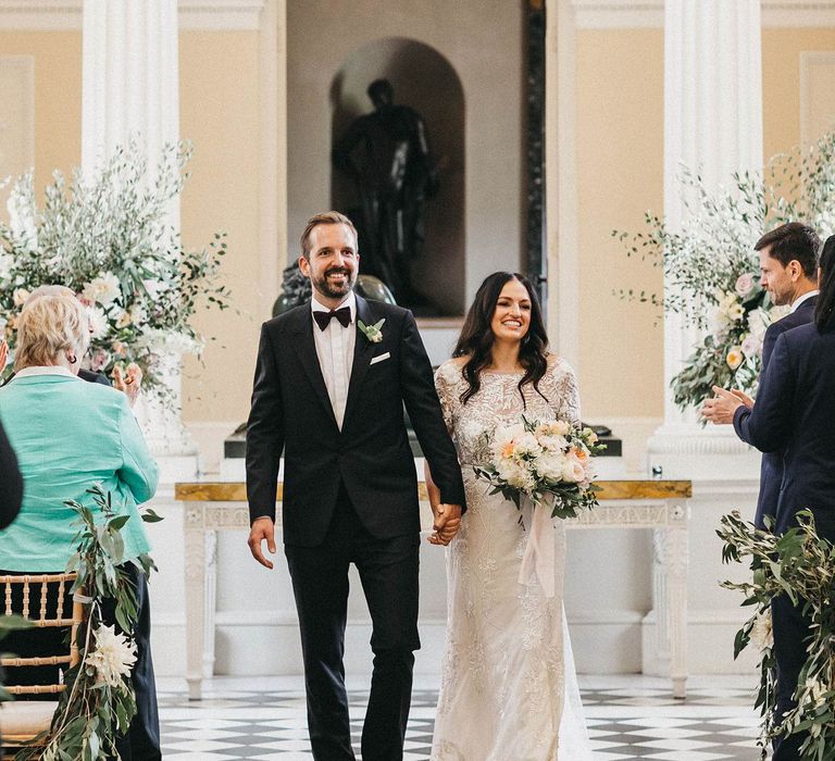 Just Married | Exit of the Bride and Groom | Bride in Hermione de Paula Wedding Gown with Short Sleeves and Personalised Embroidery | Cathedral Veil | Groom in Navy Lanvin Tuxedo and Black Burberry Shoes | Burgundy Bow Tie | Blush, Cream and Pink Bridal Bouquet | Stunning Syon Park Wedding with Quill Stationery Suite | Nancy Ebert Photography