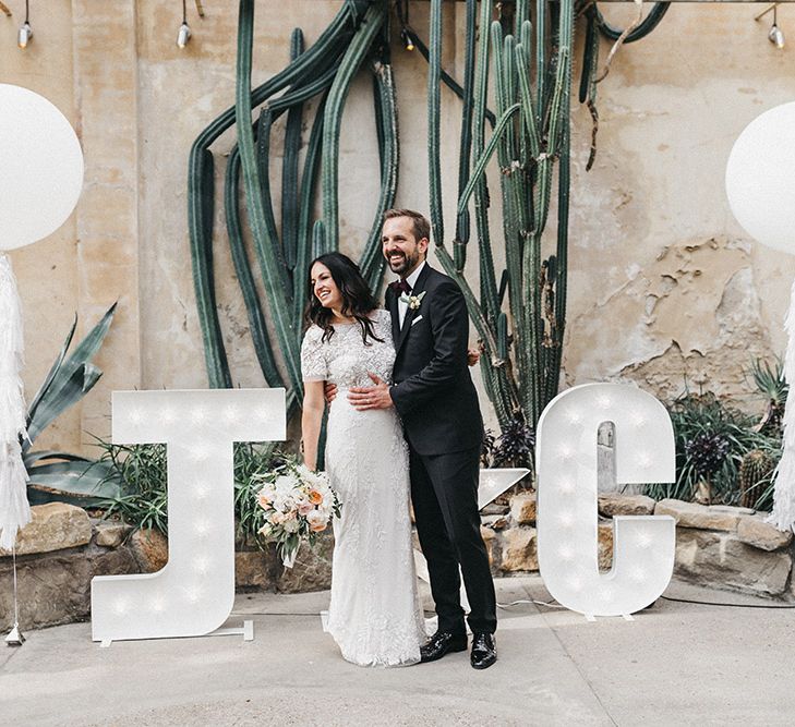 The Cactus House at Syon Park | Giant White Balloons | Giant Letter Lights | Bride in Hermione de Paula Wedding Gown with Short Sleeves and Personalised Embroidery | Cathedral Veil | Groom in Navy Lanvin Tuxedo and Black Burberry Shoes | Burgundy Bow Tie | Blush, Cream and Pink Bridal Bouquet | Stunning Syon Park Wedding with Quill Stationery Suite | Nancy Ebert Photography