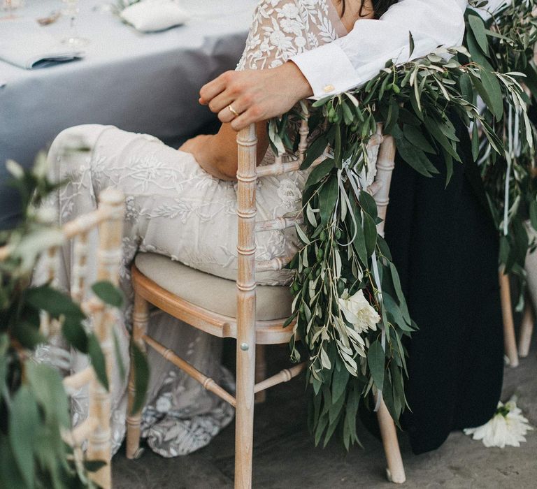 Bride and Groom During Wedding Breakfast | Top Table | Foliage Decoration for Chairs | Bride in Hermione de Paula Wedding Gown with Short Sleeves and Personalised Embroidery | Stunning Syon Park Wedding with Quill Stationery Suite | Nancy Ebert Photography