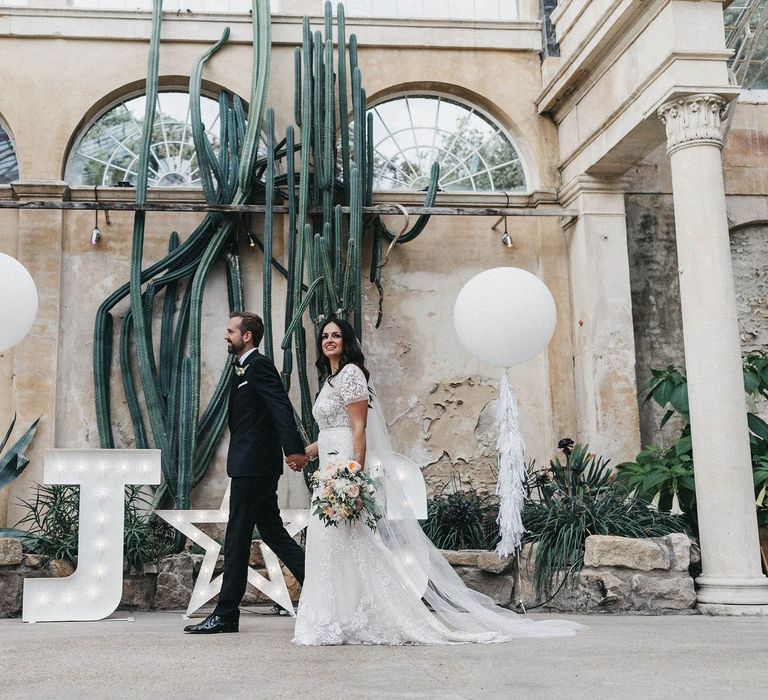 The Cactus House at Syon Park | Giant White Balloons | Giant Letter Lights | Bride in Hermione de Paula Wedding Gown with Short Sleeves and Personalised Embroidery | Cathedral Veil | Groom in Navy Lanvin Tuxedo and Black Burberry Shoes | Burgundy Bow Tie | Blush, Cream and Pink Bridal Bouquet | Stunning Syon Park Wedding with Quill Stationery Suite | Nancy Ebert Photography