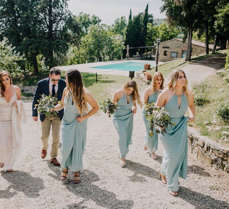 Bridesmaid dresses in mint green make their way to ceremony