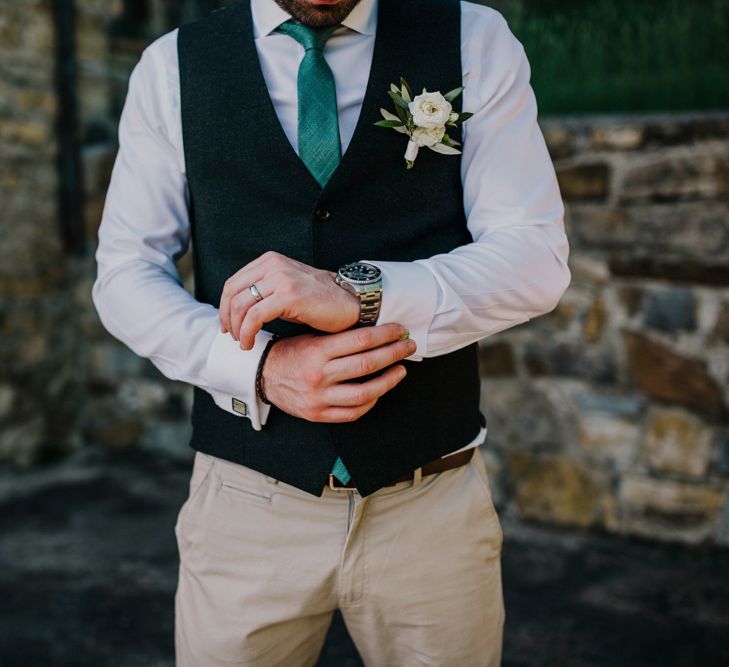 Groom in waistcoat with green tie and flower buttonhole