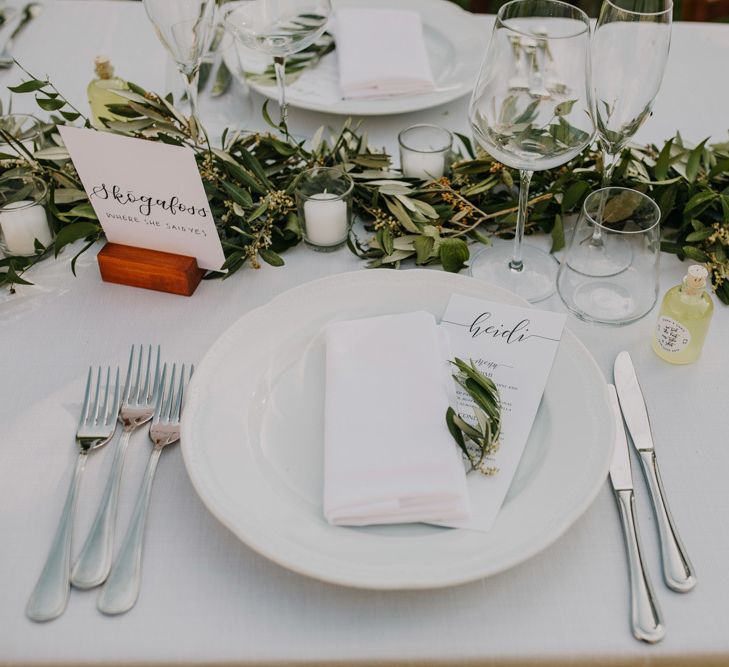 Wedding table place setting with foliage table runner at wedding with bridesmaid dresses in mint green