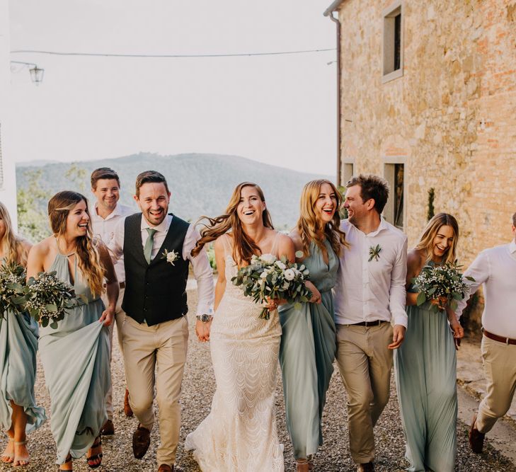 Groomsmen in cream trousers and bridesmaid dresses in mint green