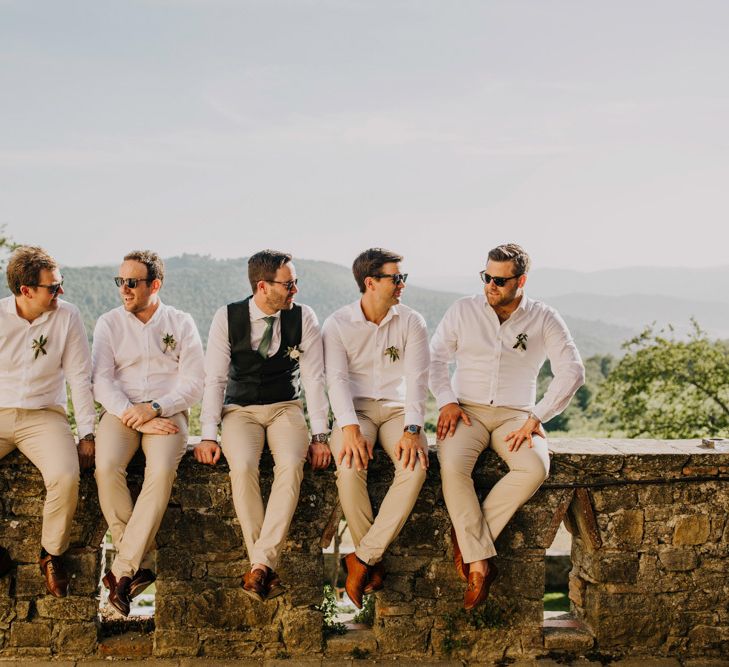 Groomsmen in matching cream trousers and bridesmaid dresses in mint green