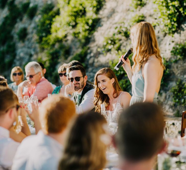 Guests enjoy the wedding speeches from bridal party with bridesmaid dresses in mint green