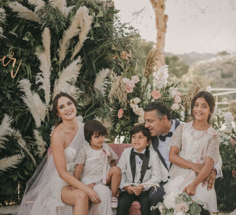 Stylish Bride and Groom Sitting with Their Children