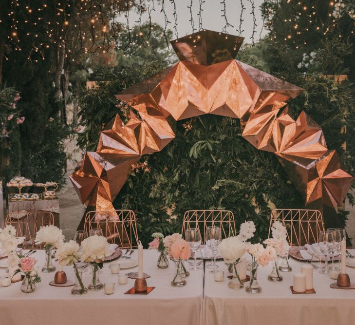 Top Table Wedding Decor with Copper Geometric Structure, Flower Stems in Vases and Geode Wedding Cake