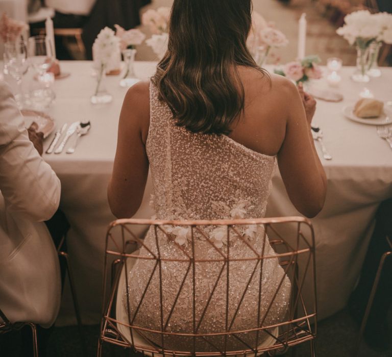 Bride in Beaded One Shoulder Muse by Berta Wedding Dress Sitting at the Outdoor Wedding Reception