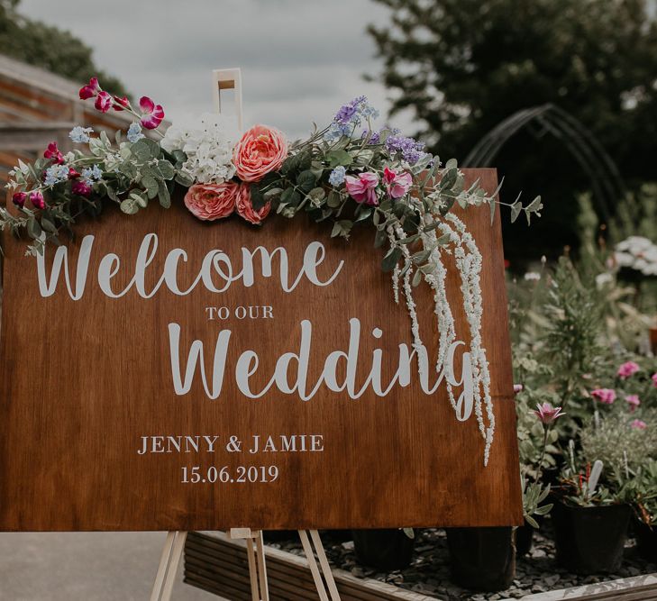 Wooden wedding welcome sign with flower decoration