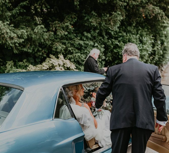 Bride arrives in blue wedding car with father