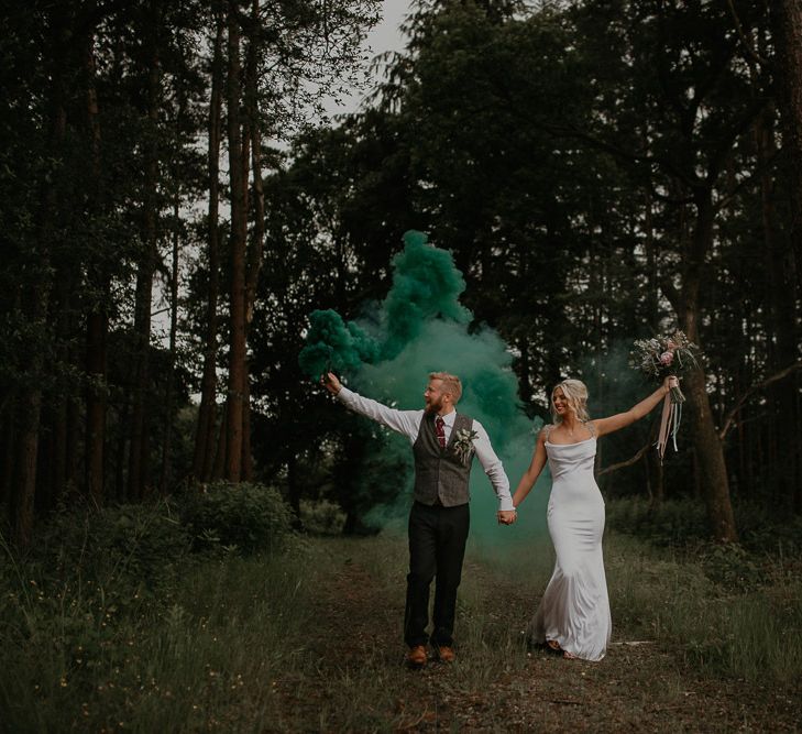 Blue smoke bomb at Cumbria wedding with bride in embroidered veil