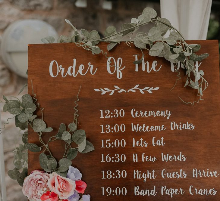 Wooden wedding order of the day with pastel wedding flowers