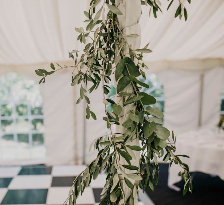 Foliage Garland Wrapped Around Marquee Pole | Outdoor Seating Area and Macaroon Tower at French Chateau Wedding | Lush Imaging