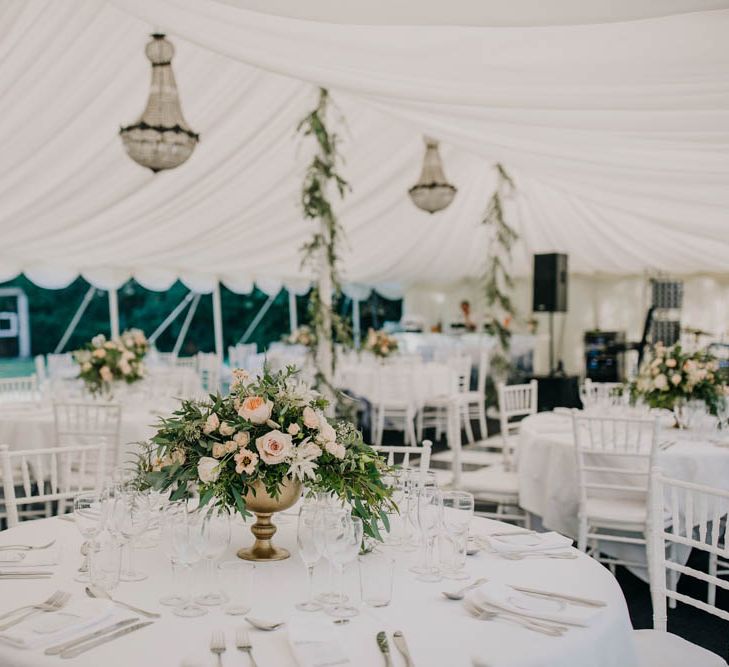 Table Centrepieces of Blush and White Flowers with Foliage in Gold Urns | Foliage Garlands Wrapped Around Marquee Poles | Gold Cutlery | Marquee with Open Side at Chateau La Durantie, Dordogne | Outdoor Seating Area and Macaroon Tower at French Chateau Wedding | Lush Imaging