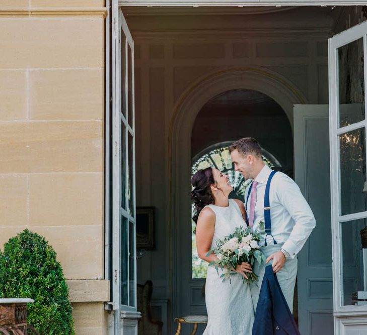 Bride in Lace Boat Neck Pronovias Wedding Dress with Keyhole Back and Fishtail Train | Bridal Bouquet of Blush and White Flowers with Foliage | Groom in Navy Jacket, Grey Trousers and White Shirt with Pink Tie from Suit Supply | Chateau La Durantie, Dordogne | Outdoor Seating Area and Macaroon Tower at French Chateau Wedding | Lush Imaging