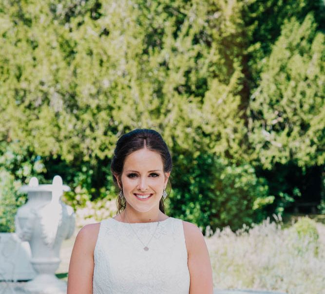 Bride in Lace Boat Neck Pronovias Wedding Dress with Keyhole Back and Fishtail Train | Bridal Bouquet of Blush and White Flowers with Foliage | Outdoor Seating Area and Macaroon Tower at French Chateau Wedding | Lush Imaging