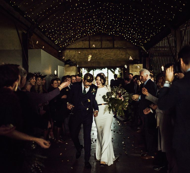 Confetti Exit with Bride in French By Wendy Makin Wedding Dress and Groom in Navy Suit