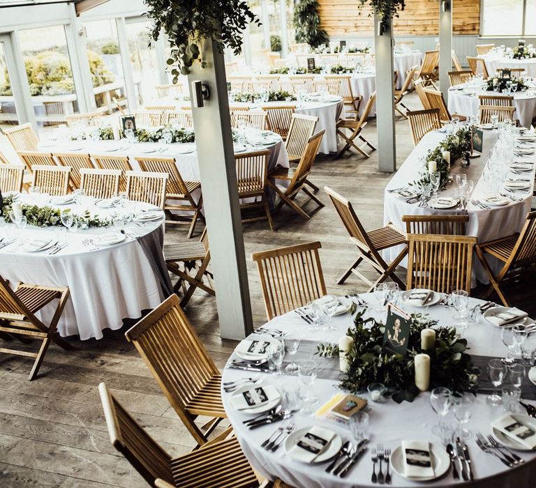 Stone Barn Wedding Reception Decor with Foliage and Candle Light