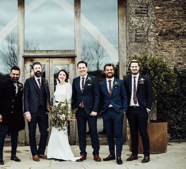 Bride in Fitted Wedding Dress Standing with the Groomsmen