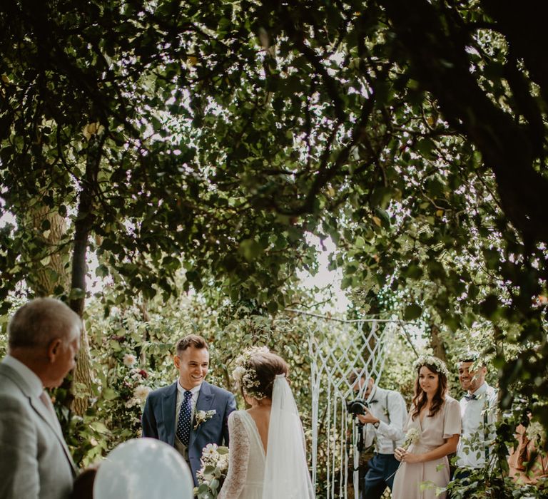 Outdoor Humanist Wedding Ceremony | Boho Bride in Flower Crown &amp; Kula Tsurdui  Wedding Dress | Groom in Navy Blue Suit  | Macramé &amp; Dreamcatcher Woodland Wedding at Upthorpe Wood | Camilla Andrea Photography