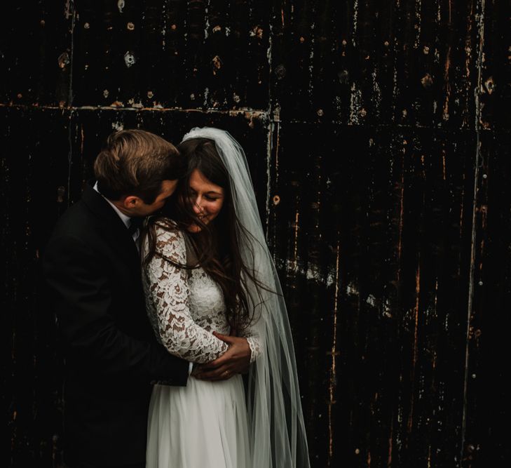 Bride in Made With Love Bridal Wedding Dress and Groom in Tuxedo Embracing