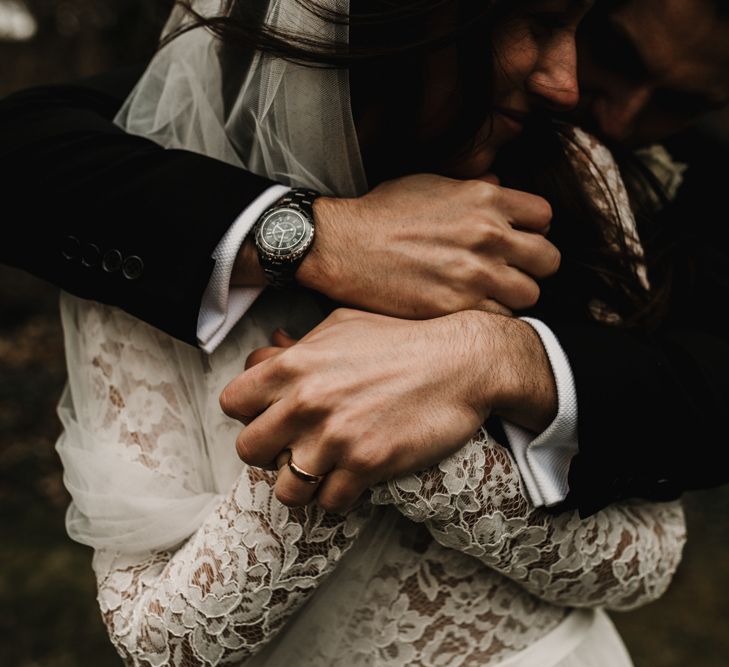 Groom Embracing his Bride in Made With Love Bridal Wedding Dress with Lace Long Sleeves