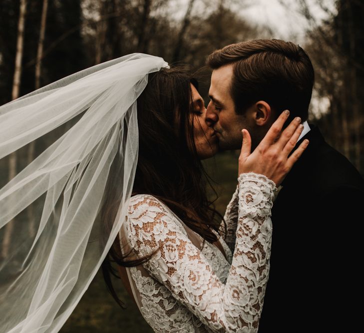 Bride and Groom Kissing with Bride in Lace Long Sleeve Made With Love Bridal Wedding Dress