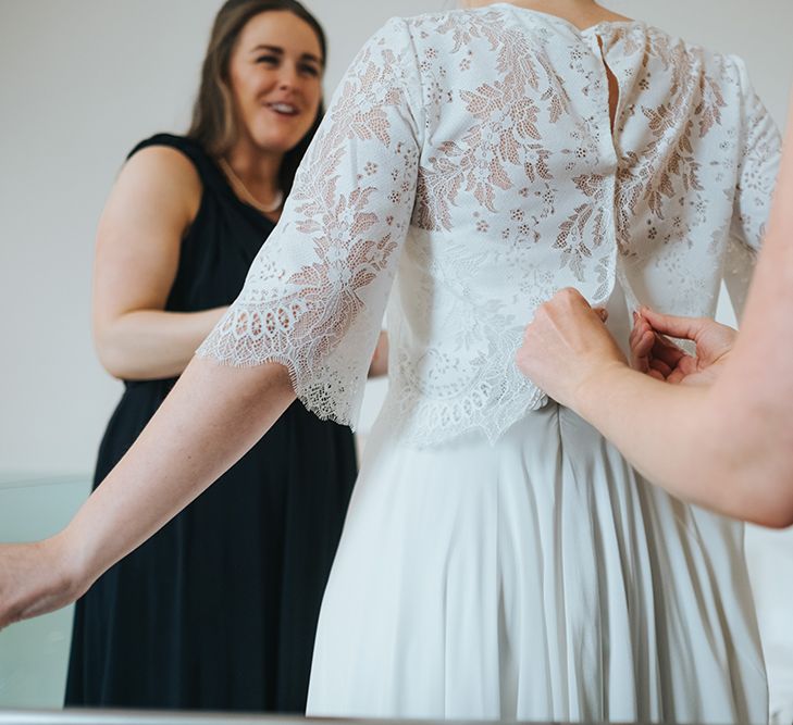 Bridal Lace Jacket by Charlie Brear | Bride in Charlie Brear Carenne Dress with Spaghetti Straps and Flowing Skirt | Bridesmaids in Navy Multiway Dresses from Debenhams | Statement Floral Arrangement Altar and Potted Plants with Copper Frame Table Plan and Lace Jacket | Miss Gen Photography