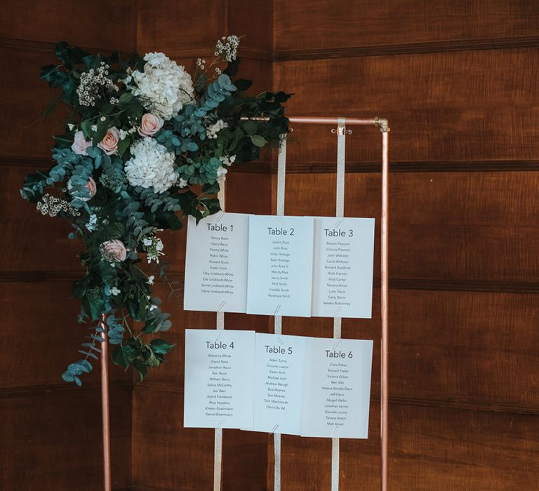 Copper Frame Table Plan | Gold Ribbon | Floral Arrangement of White Hydrangeas, Blush Roses and Foliage | Statement Floral Arrangement Altar and Potted Plants with Copper Frame Table Plan and Lace Jacket | Miss Gen Photography