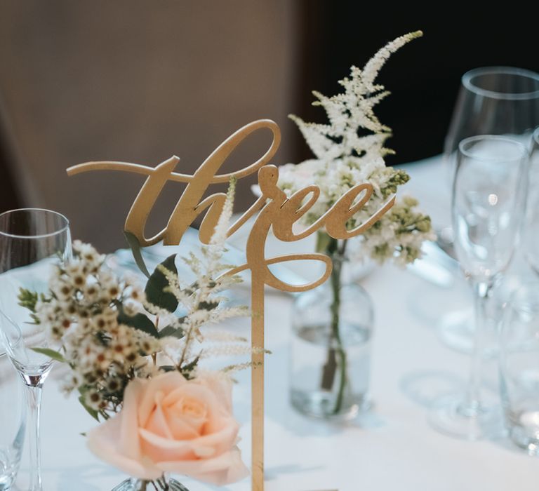 Gold Calligraphy Table Numbers | Blush Roses and Foliage in Bud Vases | Papier Place Cards | Statement Floral Arrangement Altar and Potted Plants with Copper Frame Table Plan and Lace Jacket | Miss Gen Photography