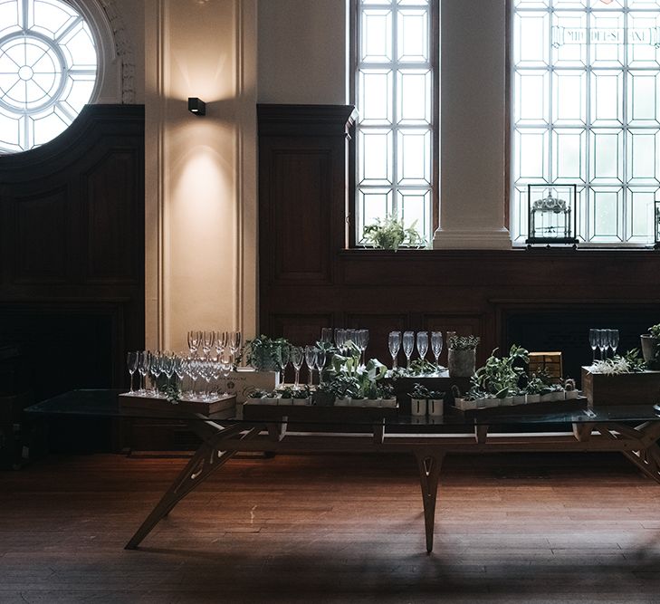 Champagne Table Decorated with Succulents and Wooden Crates | Wedding Reception at Town Hall Hotel | Statement Floral Arrangement Altar and Potted Plants with Copper Frame Table Plan and Lace Jacket | Miss Gen Photography