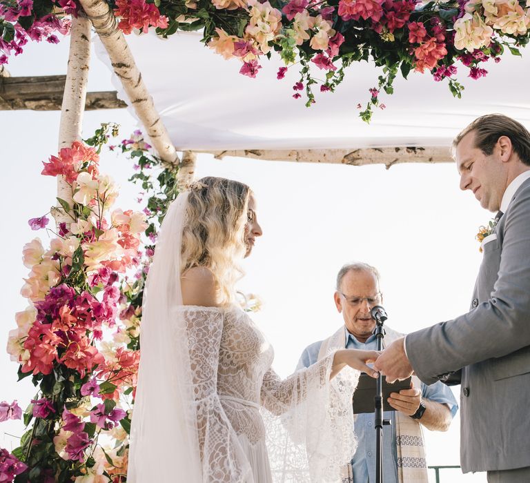 Boho Bride in Bardot Tulle and Lace Flora Bridal Wedding Dress and Groom in Grey Suit Saying Their Vows