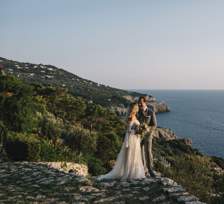 Coastal Portrait of Boho Bride in Bardot Tulle and Lace Flora Bridal Wedding Dress and Groom in Grey Ralph Lauren Suit