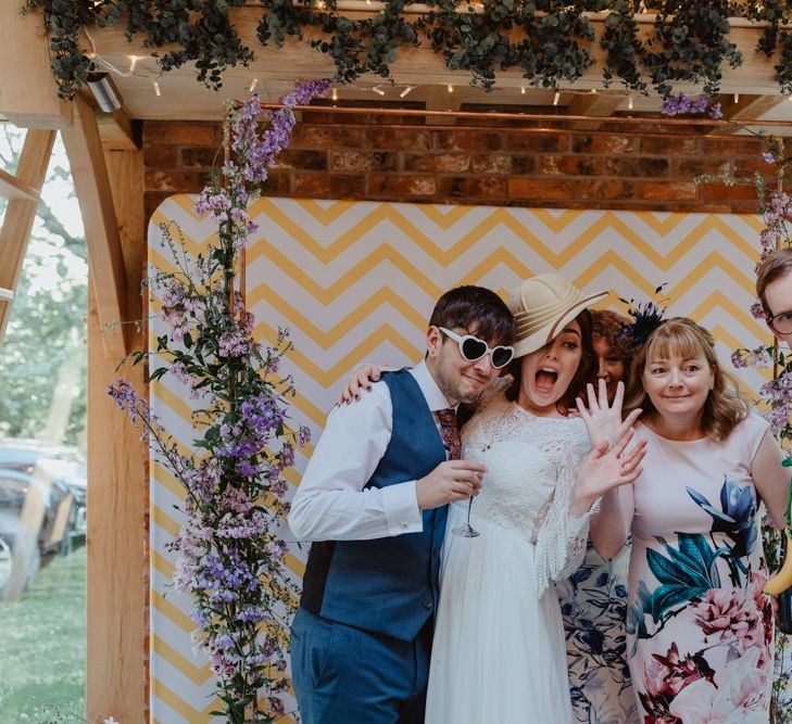 Bride and Guests Enjoy Photo Booth With Props