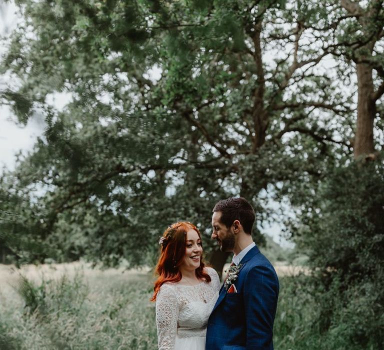 Bride and Groom Embrace In Meadows By Cheshire Wedding Venue