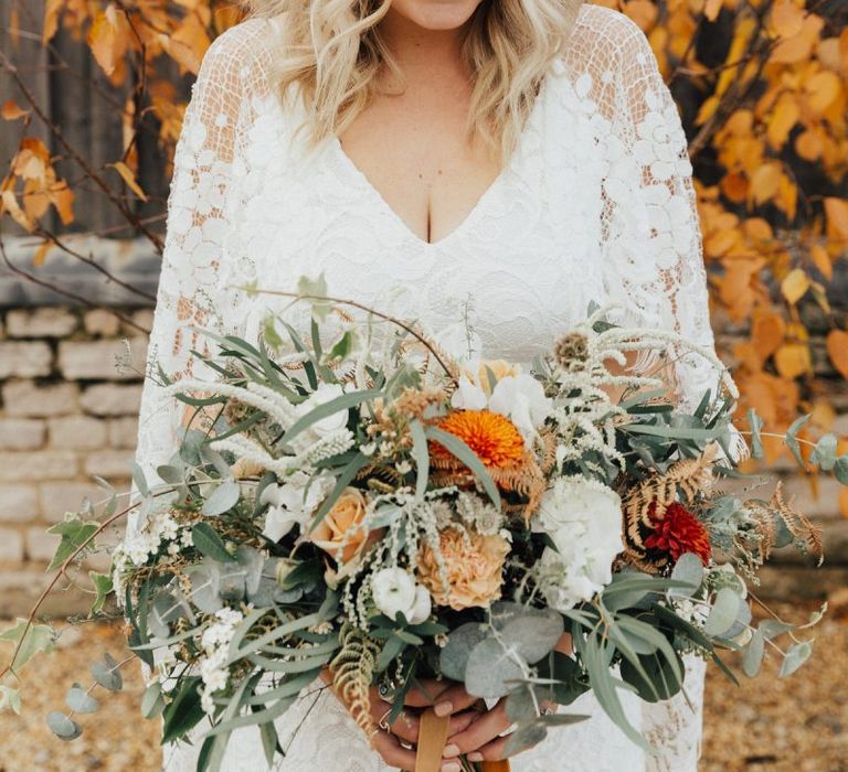 Boho Bride in Grace Loves Lace Wedding Dress and Foliage Flower Crown Holding an autumnal Bouquet