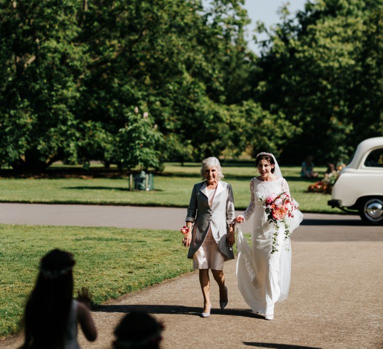 Bride walks towards her bridesmaids and flower girls waiting outside of the Nash Conservatory