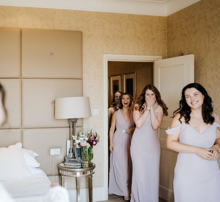 Bridesmaids see the bride in her dress for the very first time