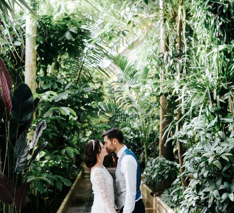 Bride and groom kiss and hold hands for Palm House at Kew Gardens wedding venue