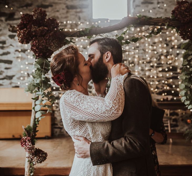 Bride and groom kiss during ceremony