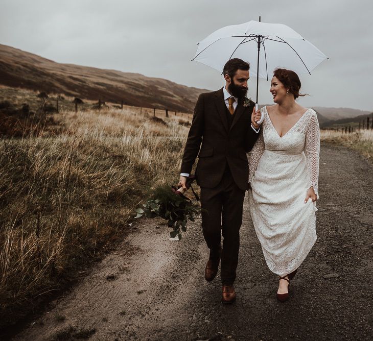 Bride and groom take a stroll in rain at Snowdonia wedding