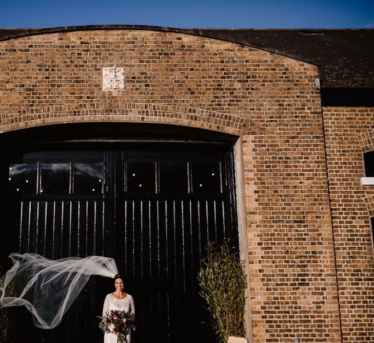 Bride in Lenora Dress by Wtoo Watters with Lace Sleeves and Keyhole Back | Prudence Halo Headpiece by Kelly Spence Wed | Floor Length Veil | String Lights, Perspex Table Signs and Paper Cranes for Industrial Wedding | Frankee Victoria Photography