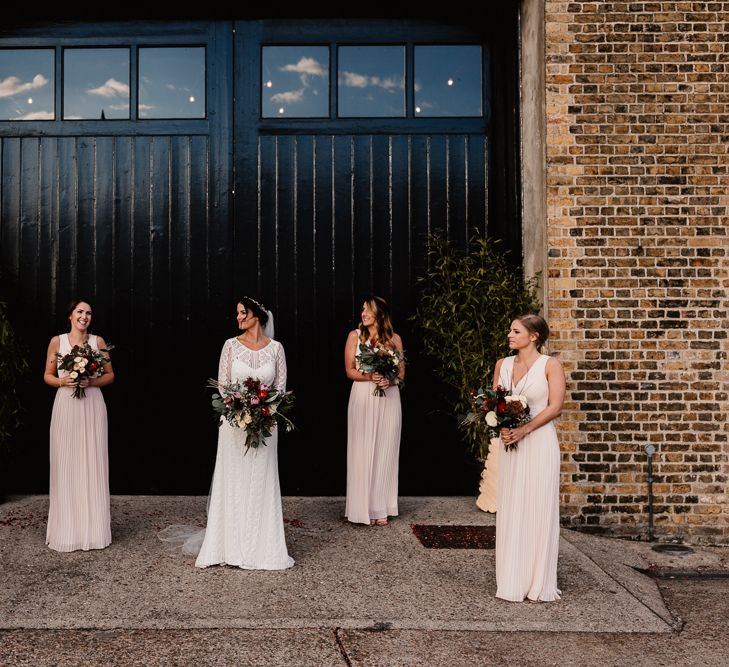 Bride in Lenora Dress by Wtoo Watters with Lace Sleeves and Keyhole Back | Prudence Halo Headpiece by Kelly Spence Wed | Floor Length Veil | Bridesmaids in Blush Pink V-Neck Dresses from ASOS | Burgundy, Blush and White Flowers with Foliage and Ferns | String Lights, Perspex Table Signs and Paper Cranes for Industrial Wedding | Frankee Victoria Photography