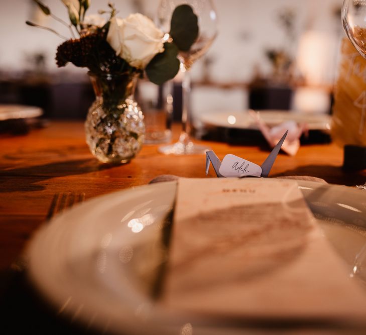 Paper Crane Place Settings | Copper and Perspex Table Sign | Flowers and Foliage in Bud Vase | Wedding Breakfast Menu | Trinity Buoy Wharf Wedding Venue | String Lights, Perspex Table Signs and Paper Cranes for Industrial Wedding | Frankee Victoria Photography