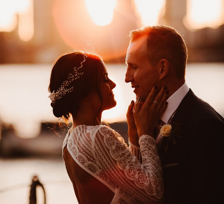 Bride in Lenora Dress by Wtoo Watters with Lace Sleeves and Keyhole Back | Prudence Halo Headpiece by Kelly Spence Wed | Groom in Navy Suit with Grey Waistcoat from Jack Bunneys | String Lights, Perspex Table Signs and Paper Cranes for Industrial Wedding | Frankee Victoria Photography