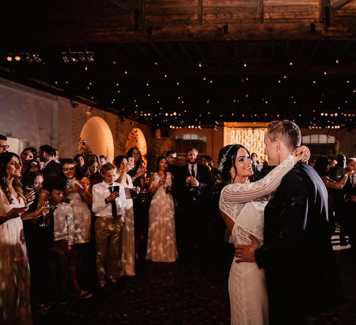 Bride in Lenora Dress by Wtoo Watters with Lace Sleeves and Keyhole Back | Prudence Halo Headpiece by Kelly Spence Wed | Groom in Navy Suit with Grey Waistcoat from Jack Bunneys | Trinity Buoy Wharf Wedding Venue | First Dance | String Lights, Perspex Table Signs and Paper Cranes for Industrial Wedding | Frankee Victoria Photography