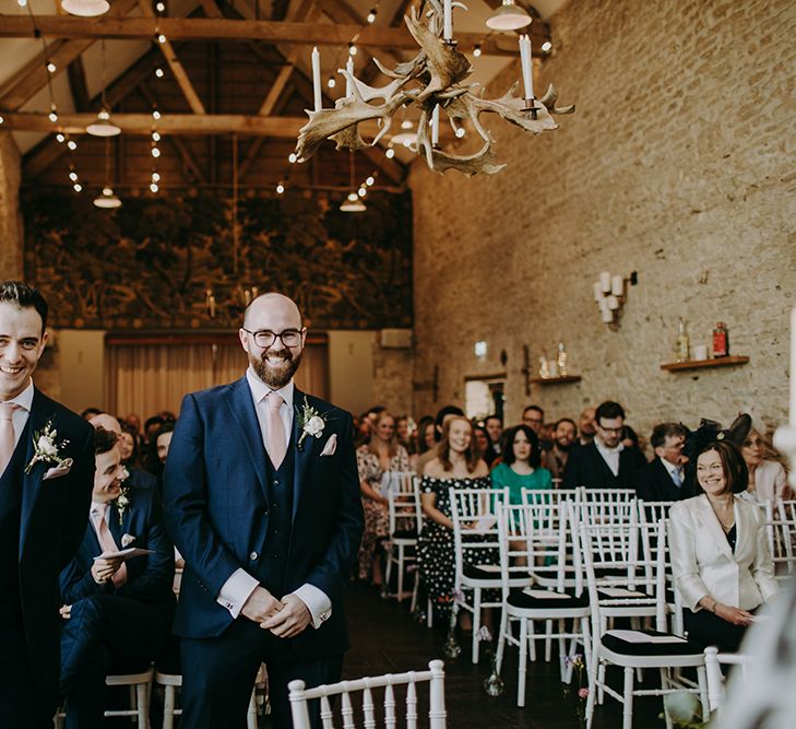 Groom and Best Man at the Altar in Navy Blue Moss Bros. Suits with Pink Ties