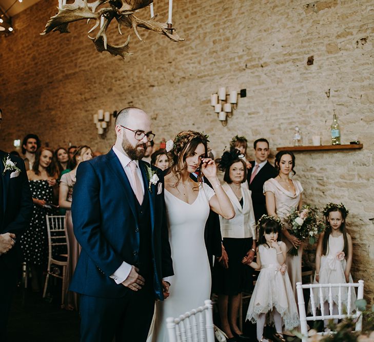 Emotional Bride in Pronovias Dralan Wedding Dress  and Groom in Navy Blue Moss Bros. Suit Standing at the Altar