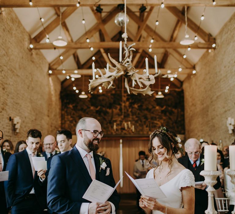 Bride in Pronovias Dralan Wedding Dress  and Groom in Navy Blue Moss Bros.  Suit Singing During Wedding Ceremony